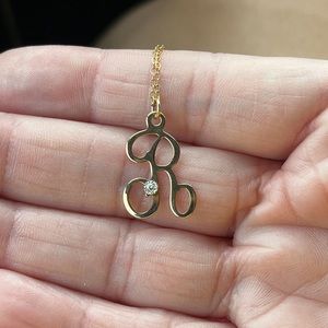 This R initial necklace with diamond chip is 14kt gold plated